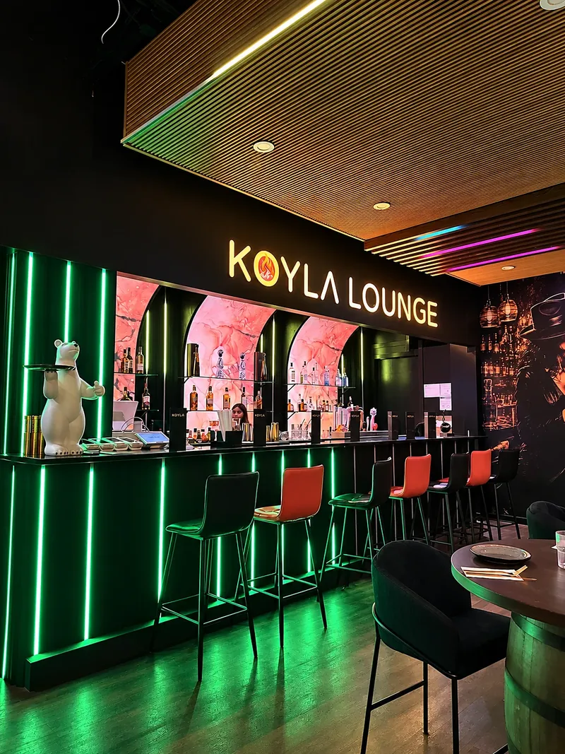 The KOYLA LOUNGE bar lit green, with the polar bear waiter