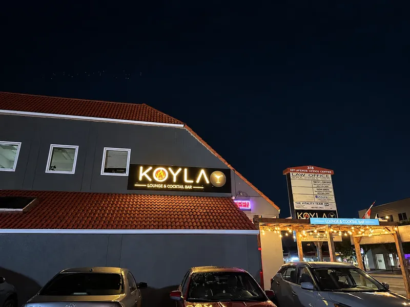 Koyla's illuminated sign on 16 Ave NW at night
