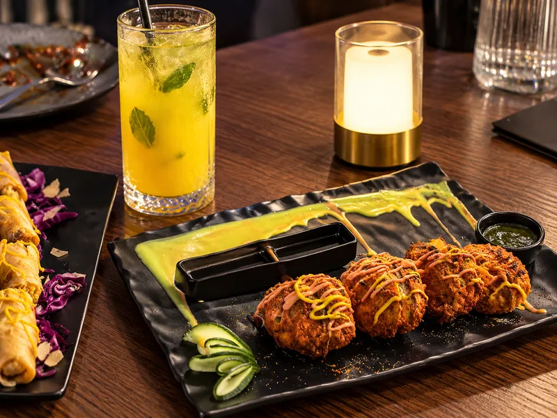 Kebabs on a slate board with a mint and lemon mocktail